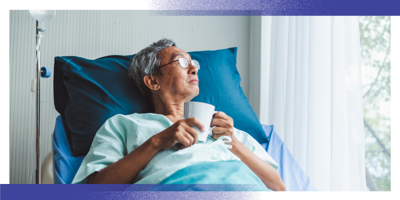 A patient sits upright in a hospital bed, holding a mug while looking towards a window. The patient is wearing a hospital gown and is supported by pillows, with medical equipment visible beside the bed. The image illustrates hospital care, recovery and follow-up support after illness or injury.